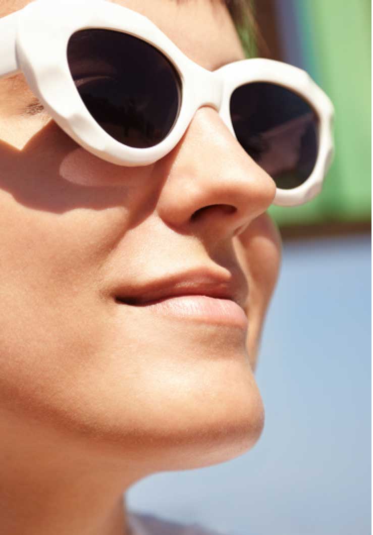 Portrait femme avec lunette de soleil au soleil